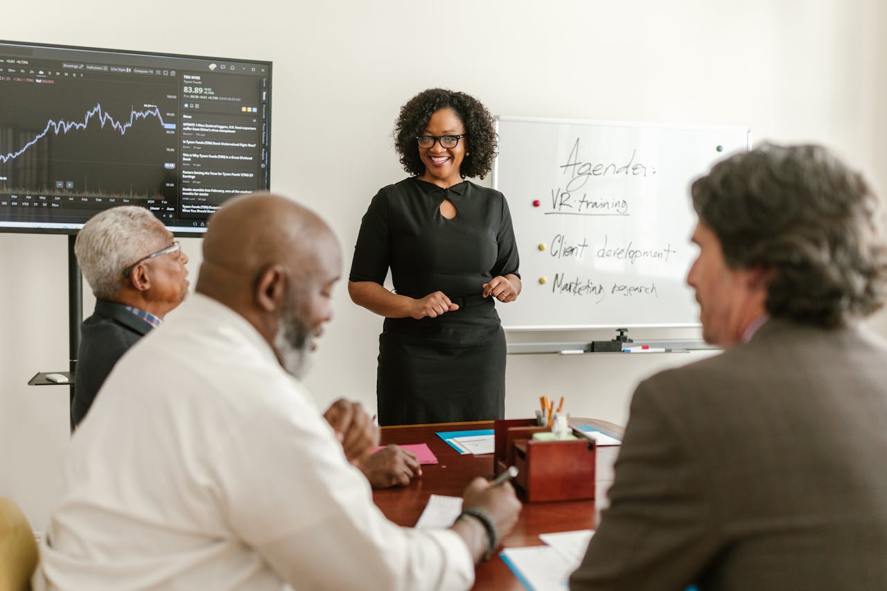Professionals in a business meeting discussing strategies and training plans with charts.